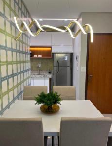 eine Küche mit einem Tisch mit Stühlen und einer Pflanze darauf in der Unterkunft Apartamento Concierge Sensacional in Marabá