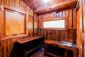 a wooden bathroom with a sink and a mirror at Rimbono Homestay in Borobudur