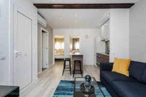 ein Wohnzimmer mit einem blauen Sofa und einer Küche in der Unterkunft Amazing Attic With Terrace in Hospitalet de Llobregat
