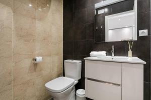 ein Badezimmer mit einem WC, einem Waschbecken und einem Spiegel in der Unterkunft Amazing Attic With Terrace in Hospitalet de Llobregat