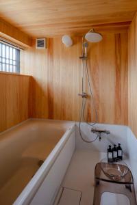 a bathroom with a tub and a shower in it at まるごの宿-耕- in Sukagawa