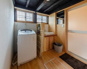 baño pequeño con lavabo y lavadora en まるごの宿-耕-, en Sukagawa