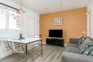 uma sala de estar com uma mesa e uma televisão em Cozy&new With Terrace em L'Hospitalet de Llobregat