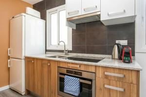 uma cozinha com um lavatório e um fogão forno superior em Cozy&new With Terrace em Hospitalet de Llobregat
