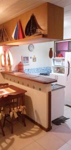 a kitchen with a table and a refrigerator at Imbassai - Casa Alto Padrão completa - Condominio Fechado - A2B1 in Imbassai