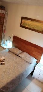 um quarto com uma cama com uma cabeceira de madeira em Imbassai - Casa Alto Padrão completa - Condominio Fechado - A2B1 em Imbassaí