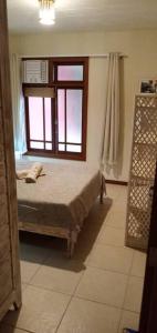 a bedroom with a bed and a window at Imbassai - Casa Alto Padrão completa - Condominio Fechado - A2B1 in Imbassai