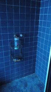 Baño de azulejos azules con aseo en una cabina en Alcoba en Polanco (solo hombres), en Ciudad de México