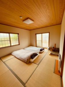 een slaapkamer met een groot bed en 2 ramen bij HIROSAKI清水森はうす in Hirosaki