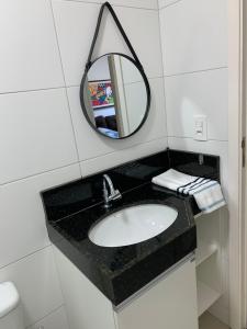 a bathroom with a sink and a mirror at SENSACIONAL A Uma Quadra da Praia da Ponta Verde in Maceió