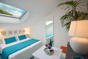 a white bedroom with a bed and a mirror at Torre Paradiso in Minori