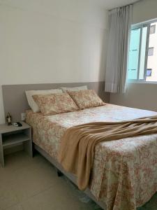 a bedroom with a large bed with a window at SENSACIONAL A Uma Quadra da Praia da Ponta Verde in Maceió
