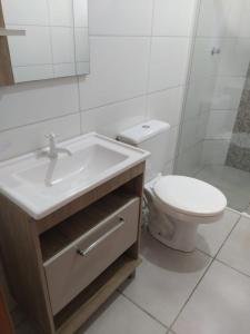y baño con lavabo, aseo y espejo. en Pousada Pontal Jurerê, en Florianópolis