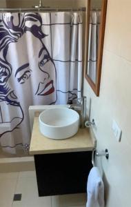 a bathroom with a sink and a shower curtain at San Marcos Suite Boutique centro quito in Quito