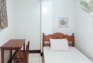 una piccola camera con letto e tavolo di RedDoorz @ Grand Valley Hotel Junction Luna Cagayan a Colonia Parcela Number One