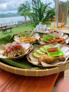 uma mesa com pratos de comida em cima em Beach Camp Lombok em Sekotong