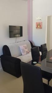 a living room with a couch and a tv and chairs at Chill Out Piria 2 in Piriápolis