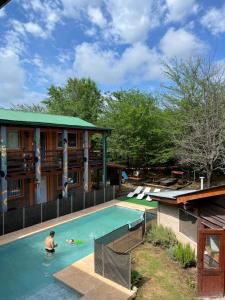 a man in a swimming pool at a resort at Eirú Hostel in Santa Rosa de Calamuchita
