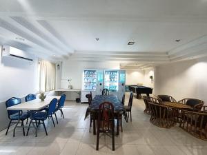 a dining room with a table and chairs and a piano at Yew Hotel in Miri