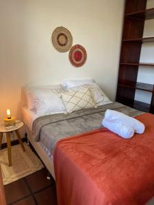 Un dormitorio con una cama y una mesa con una vela en Melasti Marine House - Casa em Condomínio Familiar com Piscina na Marina de Búzios e Wifi 1G, en Búzios