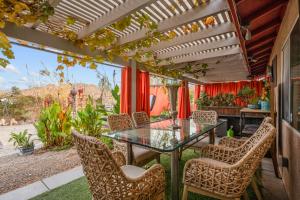 a patio with a glass table and chairs at Casa Luisa Joshua Tree in Joshua Tree