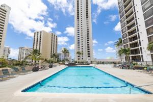 a large swimming pool with buildings in the background at Aloha Vibes, Ocean & City Views with Free Parking! in Honolulu