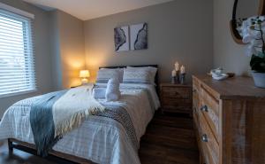 een slaapkamer met een bed en een dressoir met een spiegel bij Charming Corner Newly Furnished Townhome in Lake Harmony