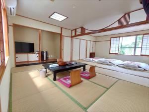 a room with two beds and a table and chairs at Okinawa Hotel in Naha