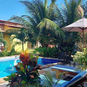 a resort with a swimming pool and palm trees at Villa da Praia in Pipa