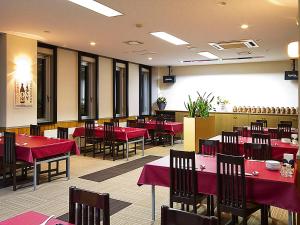 una sala da pranzo con tavoli e sedie rossi di Assabu Uzura Onsen Shiki no Yado 