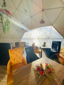 a dining room with a table with flowers and candles at Glamping Domos del Lago in Aquitania