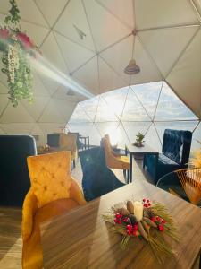 阿基塔尼亚Glamping Domos del Lago的用餐室配有带鲜花和蜡烛的桌子