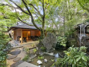 a house with a stream in front of a house at Fufu Kyoto in Kyoto