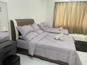 1 Schlafzimmer mit 2 Betten und lila Kissen in der Unterkunft ZaraVip homestay in Lahat