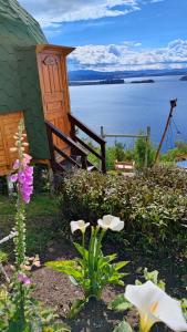 a garden with flowers in front of a building at Glamping Domos del Lago in Aquitania