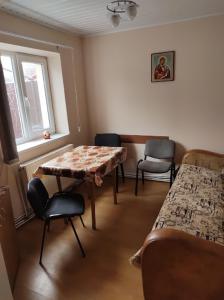 Habitación con cama, mesa y sillas. en CASA DIDINA fosta Pensiune Casa Didina en Bacău