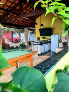 an outdoor kitchen with a table and a counter top at Villa da Praia in Pipa