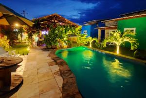 a swimming pool in the backyard of a house at night at Villa da Praia in Pipa