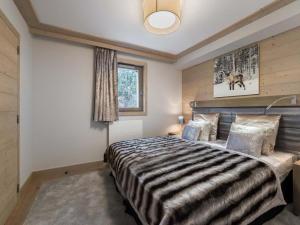 ein Schlafzimmer mit einem großen Bett und einem Fenster in der Unterkunft Appartement Courchevel 1550, 3 pièces, 6 personnes - FR-1-562-64 in Courchevel