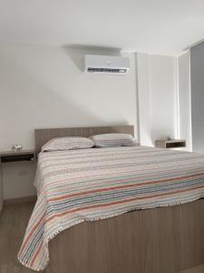 薩利納斯的住宿－Suite Nueva Salinas-Chipipe，一间卧室配有一张床,床上有条纹毯子