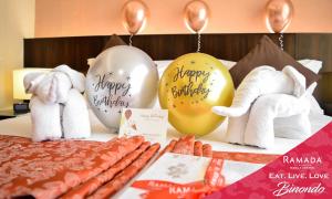 una mesa cubierta con muchos globos de cumpleaños felices y perritos calientes en Ramada by Wyndham Manila Central, en Manila