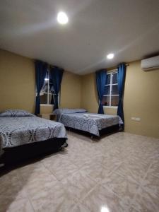1 dormitorio con 2 camas y 2 ventanas en POSADA NATIVA PALILLO´S PLACE, en Franshua
