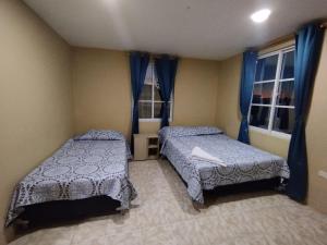 1 dormitorio con 2 camas y ventana en POSADA NATIVA PALILLO´S PLACE, en Franshua