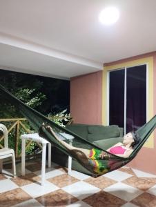 a little girl laying in a hammock in a room at POSADA NATIVA PALILLO´S PLACE in Franshua