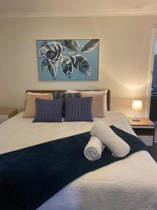 a bedroom with a bed with a blue and white blanket at Para House, Tanunda. In the heart of The Barossa Valley!. in Tanunda