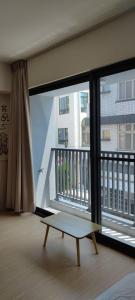 einen Balkon mit einer Bank vor einem großen Fenster in der Unterkunft IF Guest House in Tainan