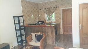 a kitchen with a counter and a sink and a chair at Kai Selfcatering Apartment in La Digue