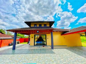 a small yellow house with a red roof at Yussy Homestay at Afamosa Villa in Kampong Alor Gajah