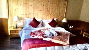 a bedroom with a large bed with red pillows at Chamba resort in Leh