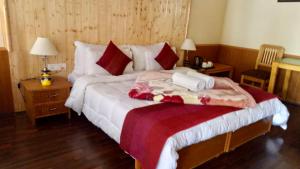 a bedroom with a large bed with two towels on it at Chamba resort in Leh